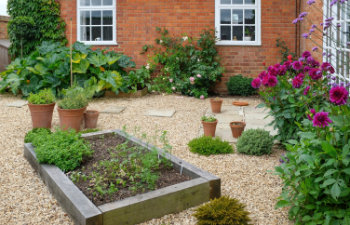 oak sleeper raised beds in a hard landscaped courtyard garden with gravel, 